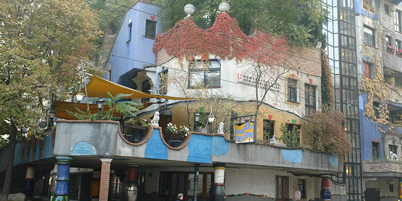 Hundertwasserhaus facade with colorful tiles and vegetation