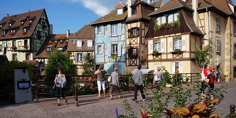 Pedestrian lane lined with painted houses in Colmar