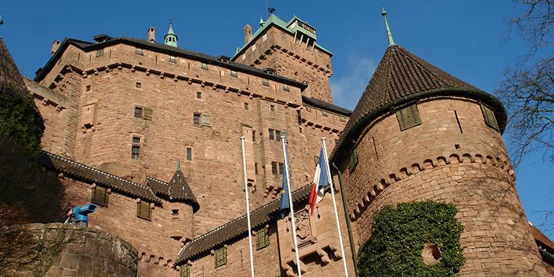 Towers and tiled roofs of Haut-Koenigsbourg against a clear blue sky