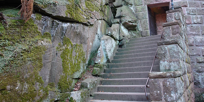 Mossy rock face and stone steps at the foot of the walls at Haut-Koenigsbourg
