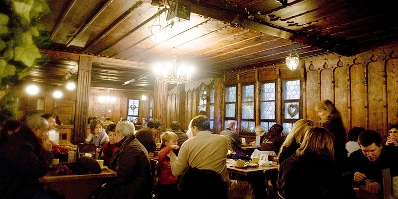 The restaurant inside the walls of Haut-Koenigsbourg with diners under a timber ceiling