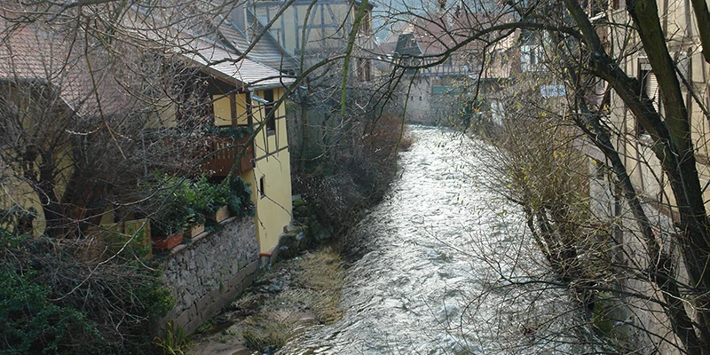 The Weiss stream in winter spate beside the old town wall in Kaysersberg