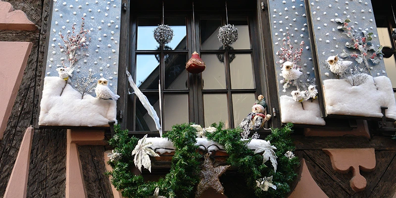 Window in Ribeauvillé decorated with snowmen and fir for Christmas