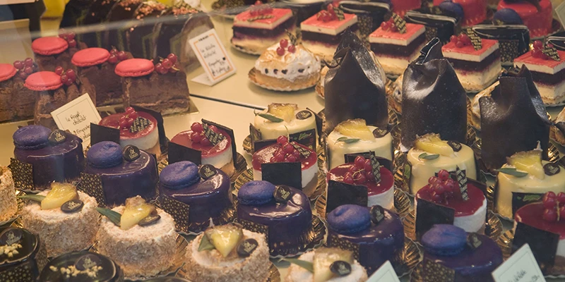 Colorful iced pastries and cakes displayed in a Ribeauvillé shop window