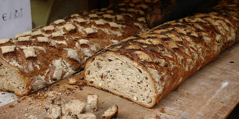 Rustic Alsatian bread loaf sliced open on a market counter in Ribeauvillé