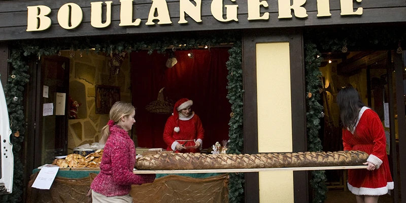 Boulangerie in Ribeauvillé with an extremely long loaf of bread carried in fresh