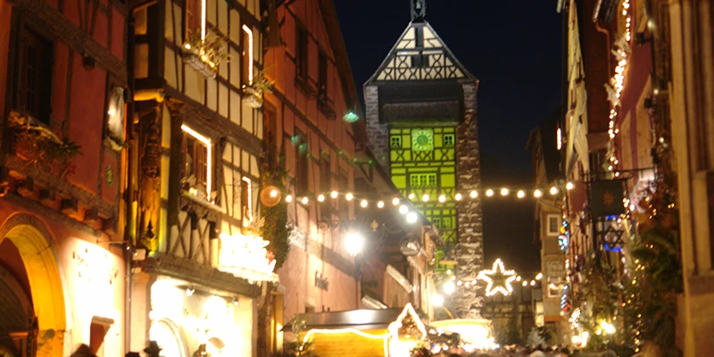Christmas lights strung above the main street of Riquewihr with the Dolder beyond