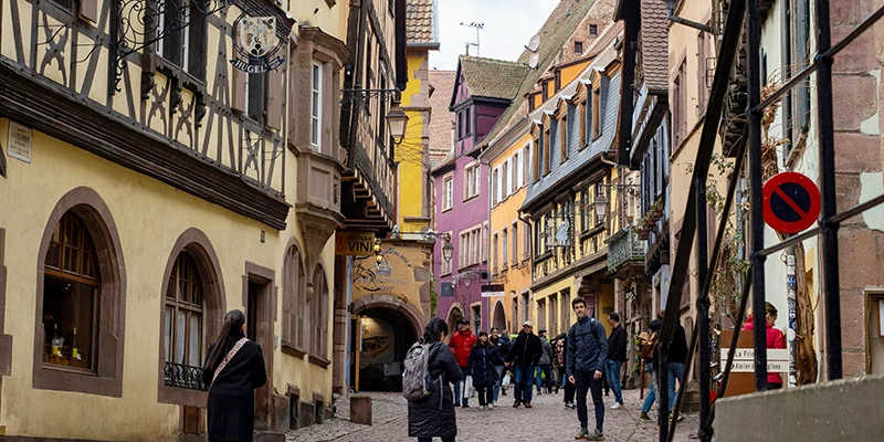 The main street of Riquewihr lined with colorful painted and half-timbered houses