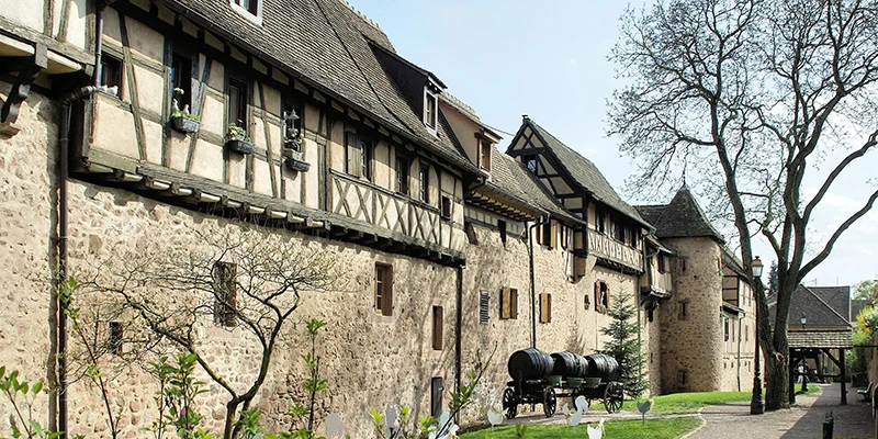 The old rampart wall of Riquewihr with a covered wagon standing outside
