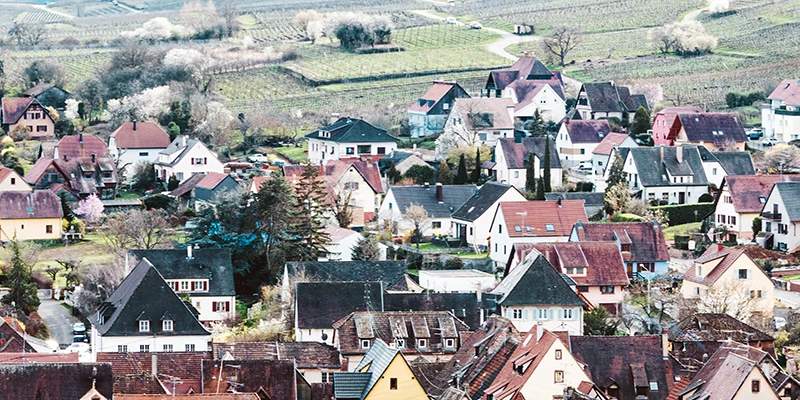 Elevated view over the tiled rooftops of Riquewihr with vineyards rising behind the village
