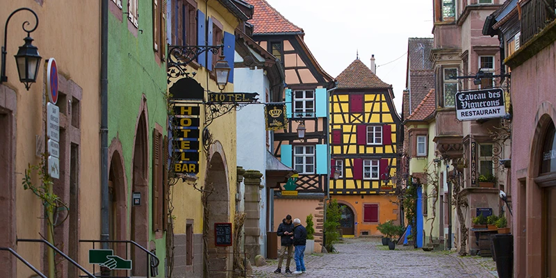 Hotel and restaurant signs on the colorful houses of the main street in Riquewihr