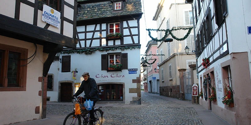 A cyclist on a half-timbered street in the Strasbourg old town
