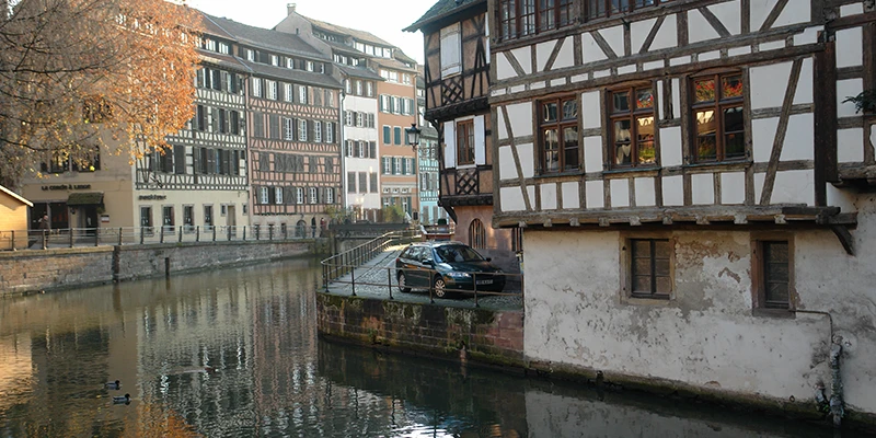 Half-timbered houses reflected in a canal in Petite France, Strasbourg, at dusk