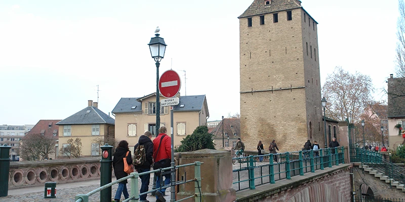 The medieval towers of the Ponts Couverts in Strasbourg with visitors on the bridge
