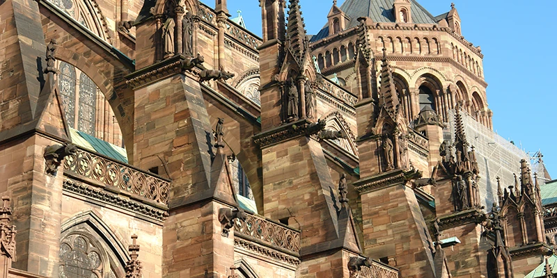 The single tower and spire of Strasbourg Cathedral against a blue sky