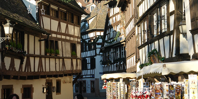 Decorated shopfronts on a half-timbered street in Strasbourg during the Christmas market