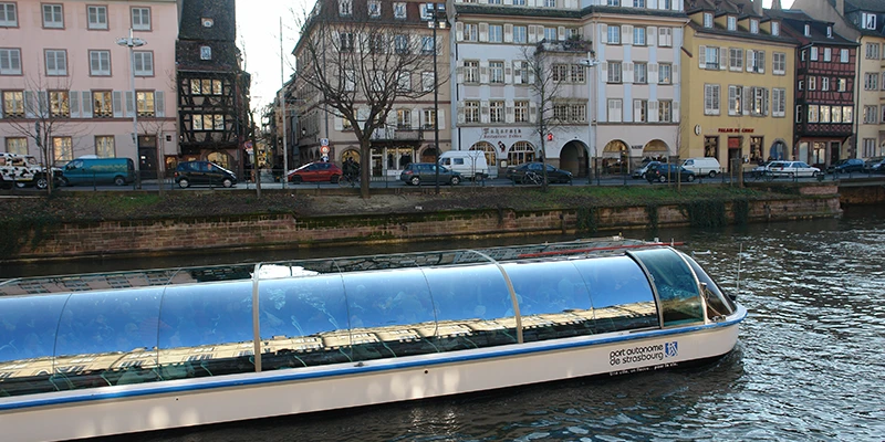 A glass-roofed tour boat on the River Ill in Strasbourg