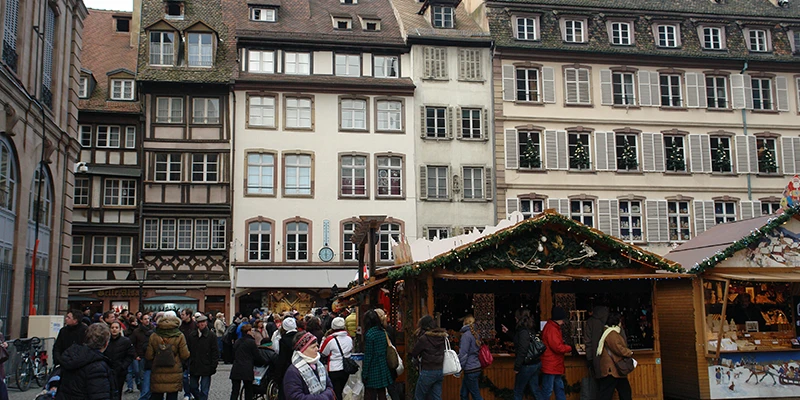 Christmas market stalls in a Strasbourg square below half-timbered houses
