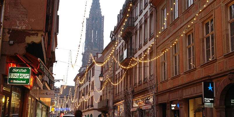 A Strasbourg shopping street with the cathedral spire rising at the end
