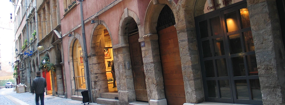 Pedestrian lane in Old Lyon lined with shopfronts and ancient facades
