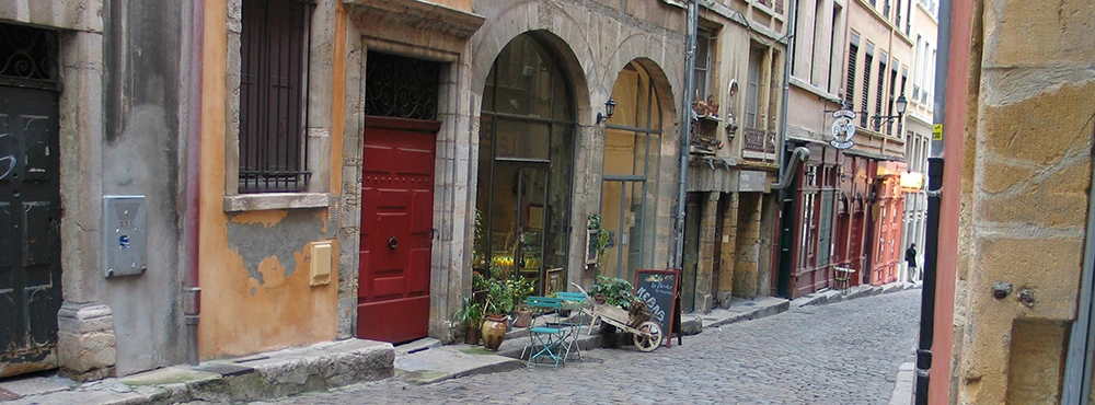 Cobbled lane in Old Lyon with a red door and potted plants