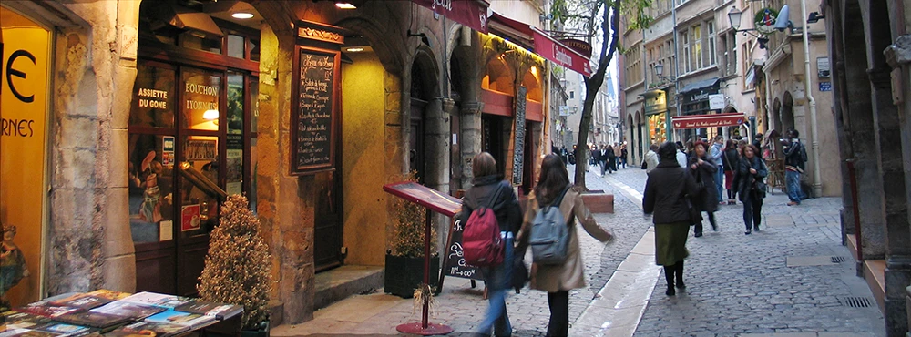 Shop displays and people walking in a lane in Old Lyon