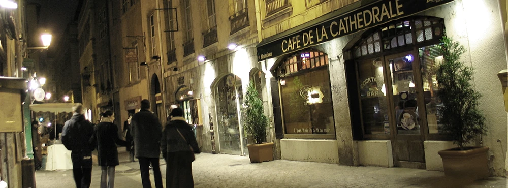 Night street in Old Lyon with lit signs above the shopfronts