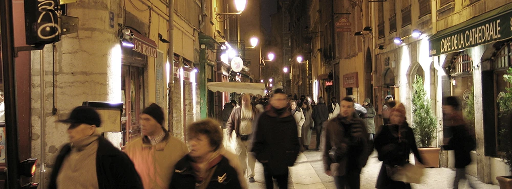 Crowd of people in a narrow Old Lyon lane in the evening
