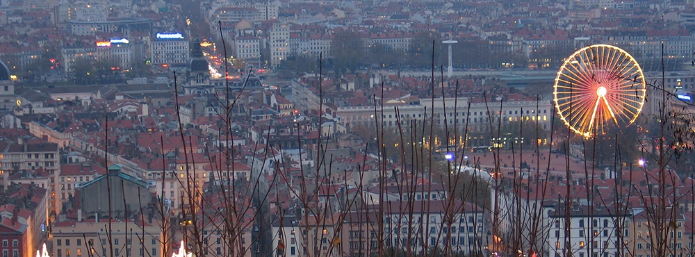 Lyon at dusk from above with a Ferris wheel among the city lights