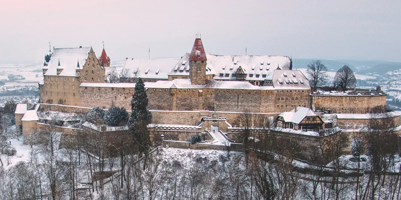 The Veste Coburg fortress complex with its towers and steep roofs above forested slopes