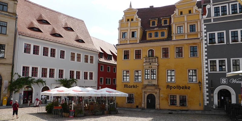 Meissen market square with the Markt-Apotheke, colourful gabled houses and café umbrellas
