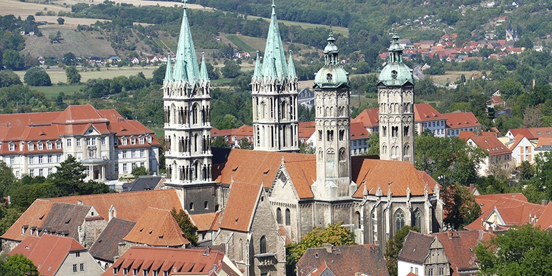 The four-towered Naumburg Cathedral rising over the town's rooftops with hills behind