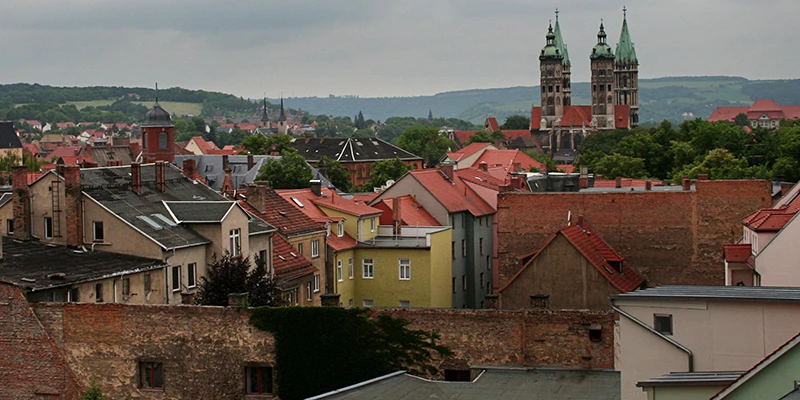 The towers of Naumburg Cathedral seen over the town rooftops on an overcast day