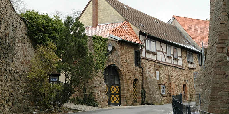 Stone gateway and timber-framed outbuilding on the approach to Wernigerode castle, lightly dusted with snow