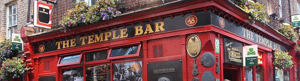 The bright red facade of the Temple Bar Pub with hanging flower baskets