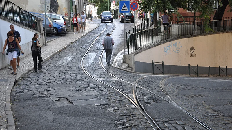 Cobbled Alfama street with tram tracks running through it