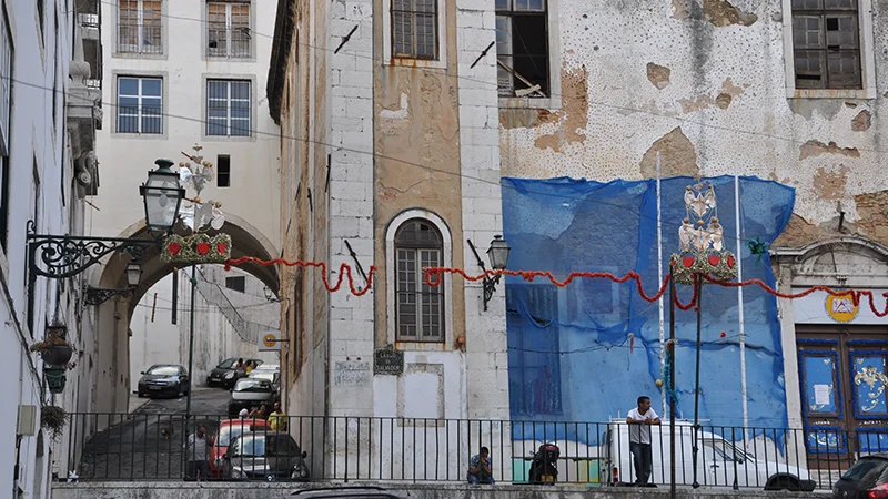 Stone archway spanning a lane in Alfama with painted signs beyond