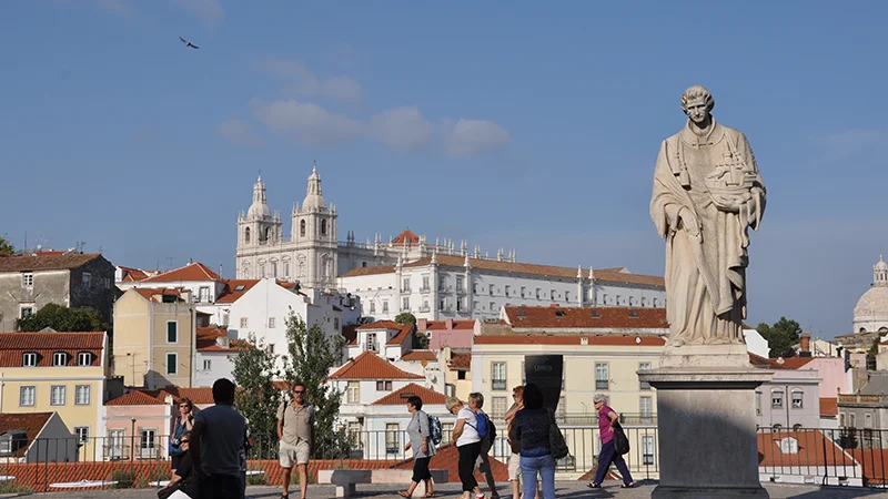View across Alfama rooftops toward the white church of Sao Vicente