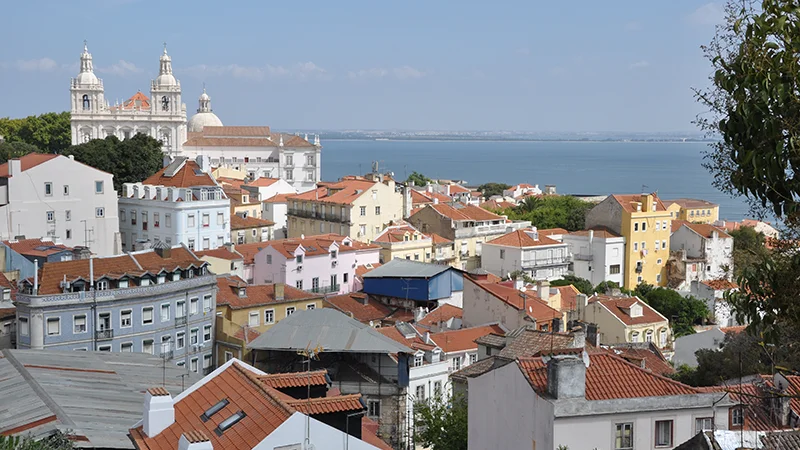 Panorama over the rooftops of Alfama toward the Tagus river in Lisbon