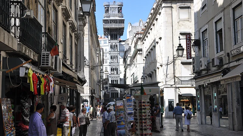 Crowded Baixa shopping street with the iron Santa Justa lift beyond