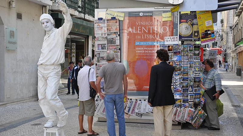 Street performer in white costume with onlookers in Lisbon