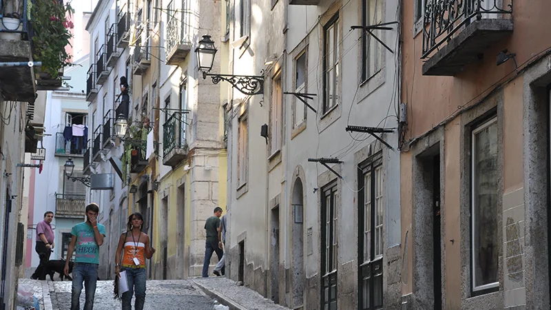 Narrow Bairro Alto street with tram wires overhead