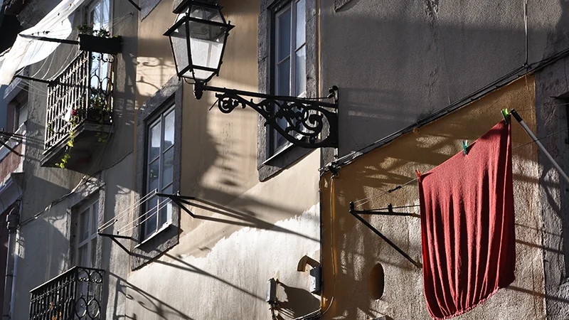 Balcony with a red curtain and a wall lamp in Bairro Alto