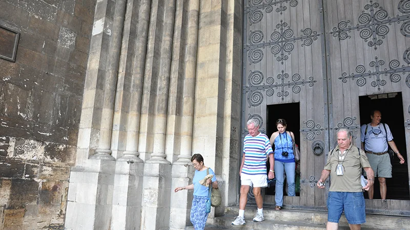 Colonnade at Lisbon Cathedral with visitors passing through
