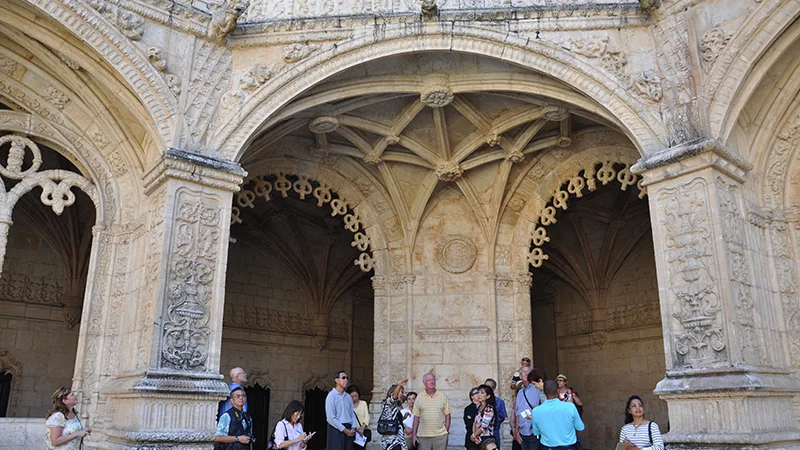 Visitors beneath the carved arches of the Jeronimos cloister