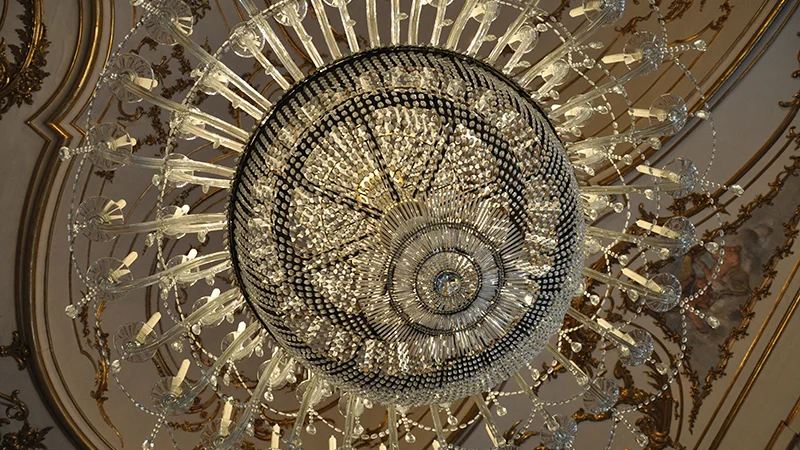 Ornate ceiling and chandelier in a room at Queluz Palace