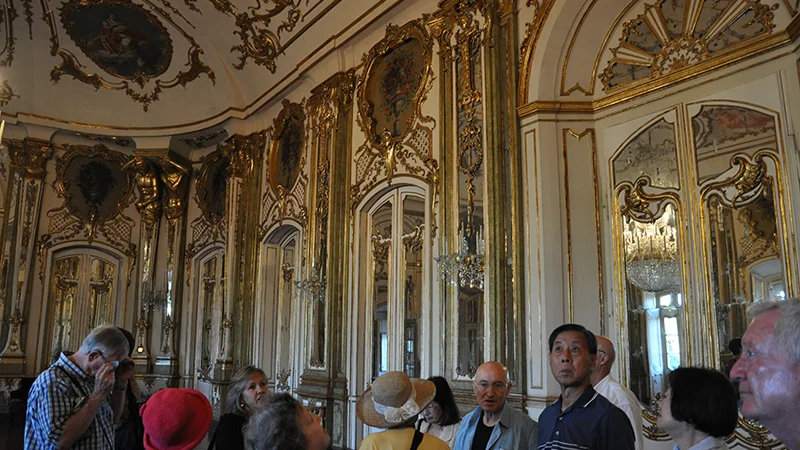 Ornate state room at Queluz Palace with visitors