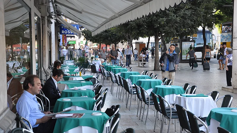 Row of green painted seats at the edge of Rossio square