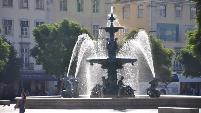 Bronze fountain throwing spray in Rossio square Lisbon