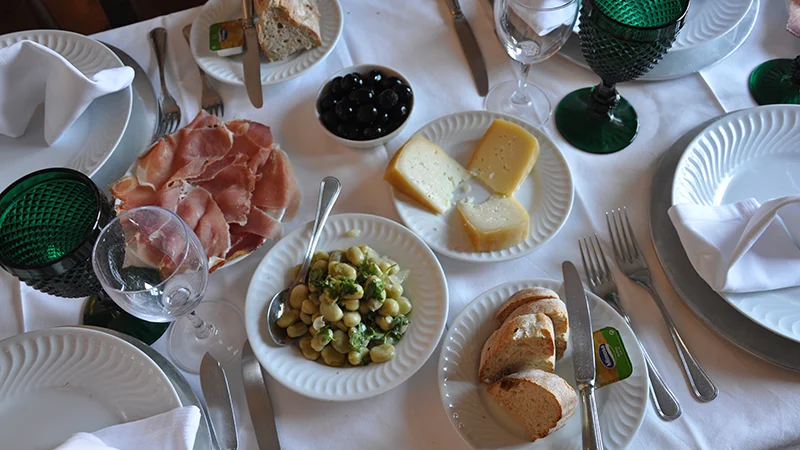 Restaurant table set with cured ham cheese olives and bread in Portugal
